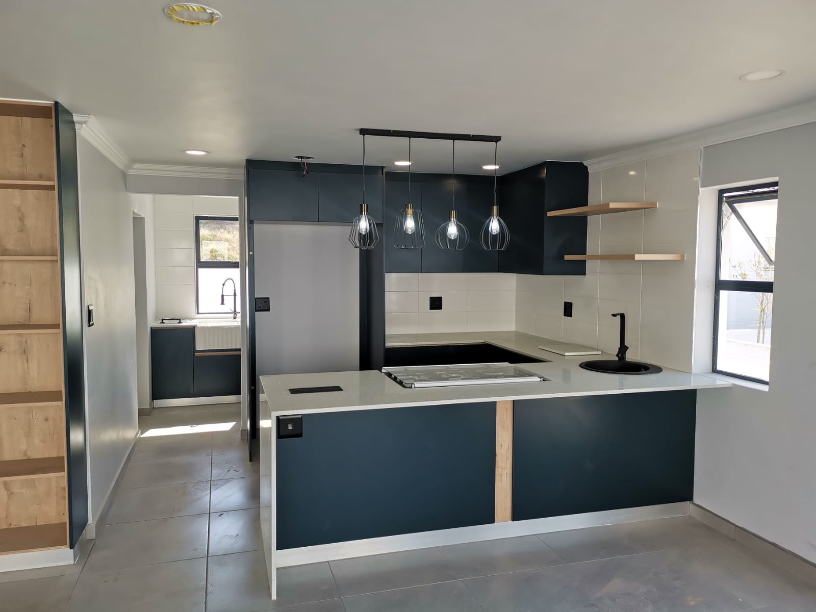 Shaker-style grey kitchen cabinetry with stone countertops