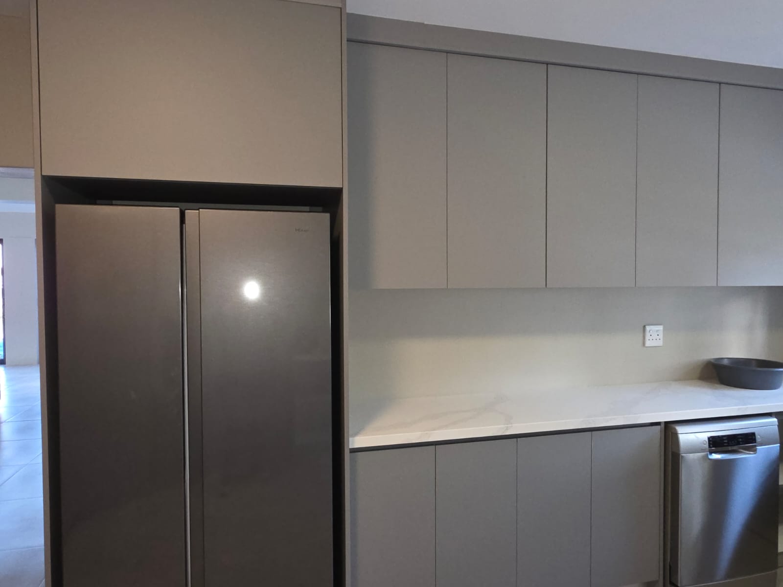 Shaker-style grey kitchen cabinetry with stone countertops