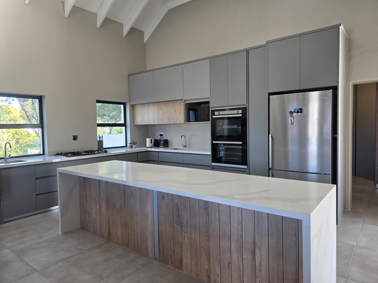 Shaker-style grey kitchen cabinetry with stone countertops